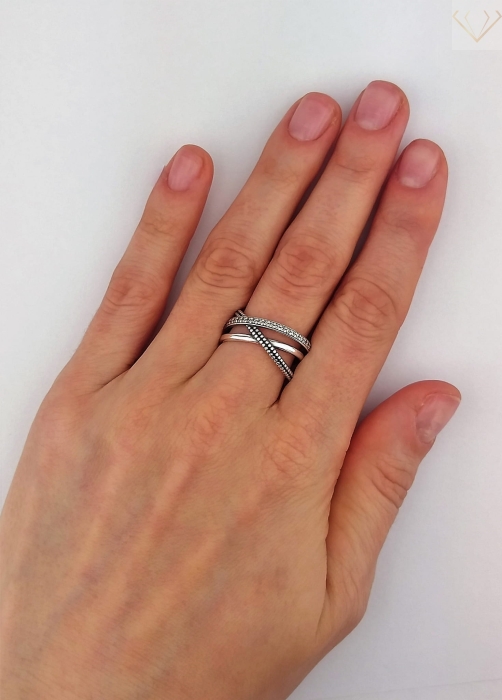 Srebrny pierścionek oksydowany przeplatany z cyrkoniami na palcu
